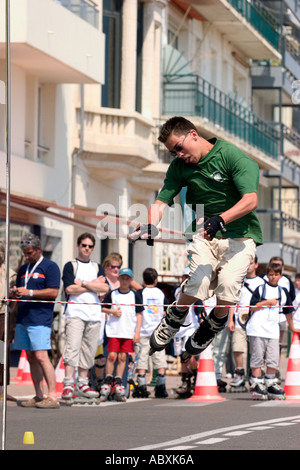 Roller skater jumping high bar Banque D'Images