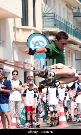 Roller skater jumping high bar Banque D'Images