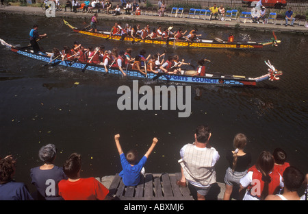 Un garçon célèbre la victoire d'un dragon boat franchir la ligne d'arrivée dans une course sur un canal, Hackney, Londres, Royaume-Uni, 1994. Banque D'Images