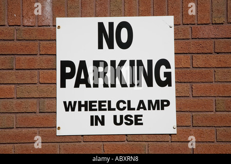 Pas de parking privée dans wheelclamps, connectez-vous sur mur de brique Wales UK Banque D'Images