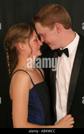 Jeune couple wearing evening dress smiling toucher le nez Banque D'Images