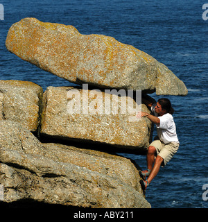 Jeune homme escalade près de Sennen Cove, Cornwall, Angleterre Banque D'Images