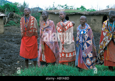 KENYA Masai Mara National Reserve Masai les femmes en costumes traditionnels et de bijoux chanter au milieu de leur village manyatta Banque D'Images