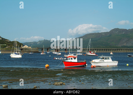 Barmouth bateaux amarrés et petits yachts dans le viaduc ferroviaire de l'estuaire de Mawddach Afon et passerelle au-delà Banque D'Images