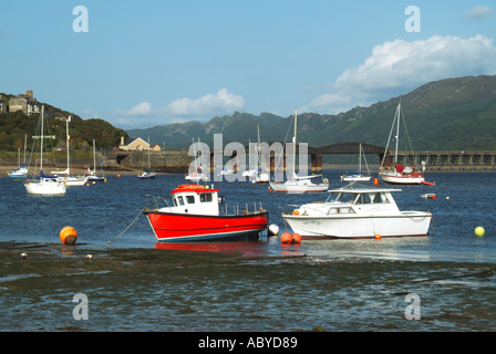 Barmouth bateaux amarrés et petits yachts dans le viaduc ferroviaire de l'estuaire de Mawddach Afon et passerelle au-delà Banque D'Images