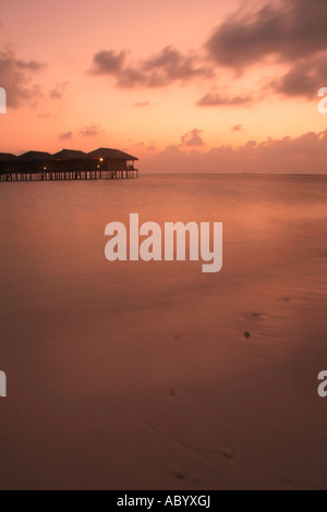 Bungalows sur l'eau au coucher du soleil le Maldives Banque D'Images