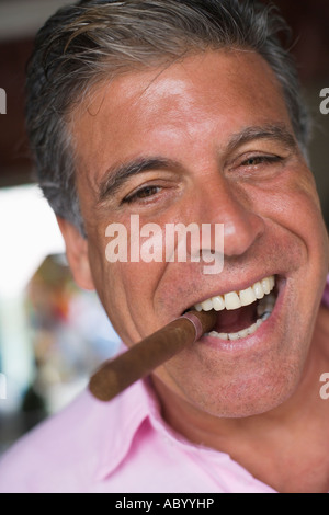 Man holding cigare dans sa bouche Banque D'Images