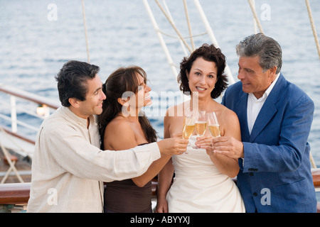 Des couples toasting each other with champagne sur pont de bateau Banque D'Images