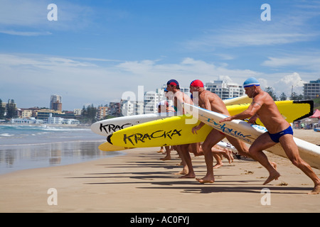 Courir pour les concurrents avec de l'eau conseils de sauvetage sous le bras lors d'une course sur la plage de Cronulla Banque D'Images