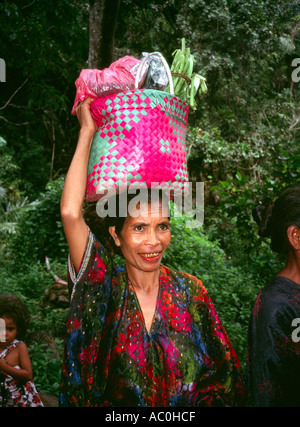 Indonésie Flores Moni femme avec du bétel dents tachées de retour de marché hebdomadaire carrying basket on head Banque D'Images