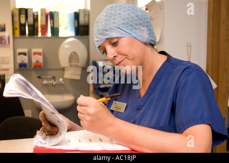 Ward Sœur en unité de chirurgie d'un jour Admission des patients' notes, Cobham, Surrey, UK. Banque D'Images