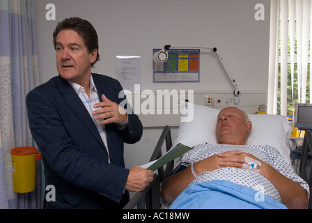 Patient supervisé par le médecin généraliste dans la salle de réveil à la suite d'une opération dans une unité de chirurgie de jour à Cobham, Surrey, Royaume-Uni. Banque D'Images