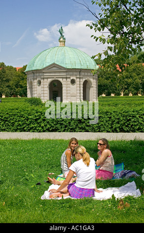 3 FEMMES SE DÉTENDRE DANS LE JARDIN ROYALE HOFGARTEN MUNICH BAVARIA ALLEMAGNE EUROPE Banque D'Images