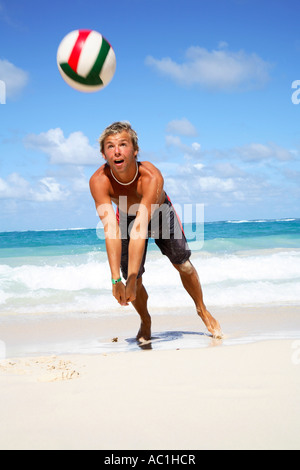 Jeune homme jouant du volley-ball sur plage Banque D'Images