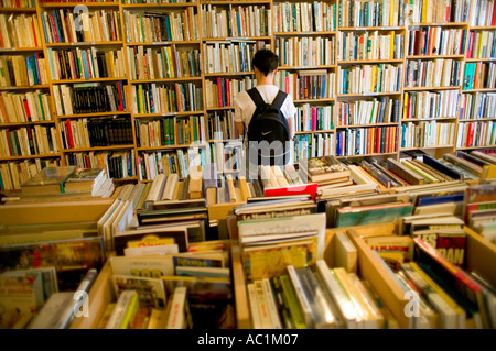 Vue arrière D'UNE FEMME EN LIBRAIRIE D'OCCASION FONTENOY-LA-JOUTE LORRAINE FRANCE EUROPE Banque D'Images