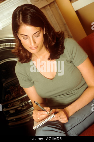 Femme assise dans un cahier d'écriture Banque D'Images