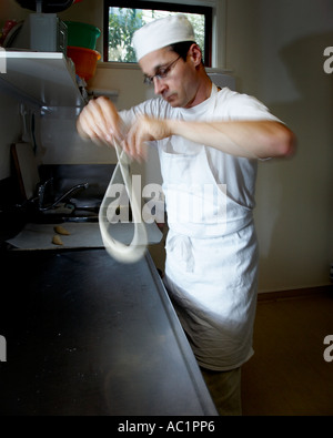 Homme baker travaillant dans un petit cottage en brezels boulangerie le pain de torsion à la main Banque D'Images