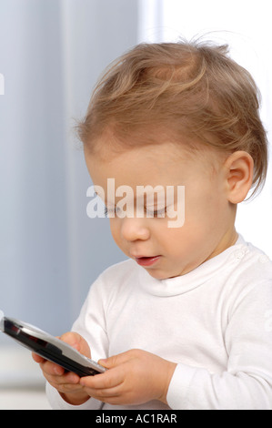 Petit enfant à l'aide de mobile phone, close-up Banque D'Images