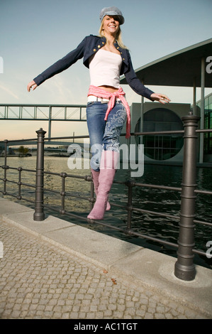 Jeune femme sautant d'railing Banque D'Images