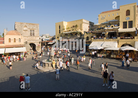 Une vue grand angle de touristes autour de la fontaine en Ippokratous Square dans le centre de la vieille ville de Rhodes. Banque D'Images