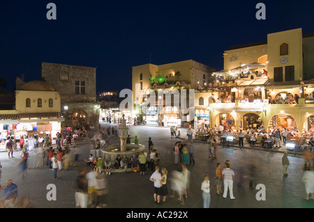 Un soir grand angle vue de la nuit de touristes autour de la fontaine dans Ippokratous Square dans le centre de la vieille ville de Rhodes. Banque D'Images