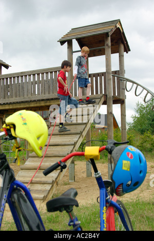 Deux jeunes garçons ont enlevé leur casque avant de jouer sur un terrain de jeux Banque D'Images