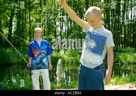 Jeune garçon présentant fièrement son poisson frais Banque D'Images