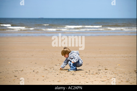 Un jeune garçon explore la mer en vacances à Nice dans le North Yorkshire England UK Banque D'Images