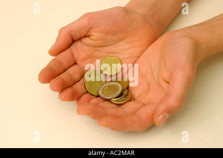 Un jeune garçon's hands holding argent Banque D'Images