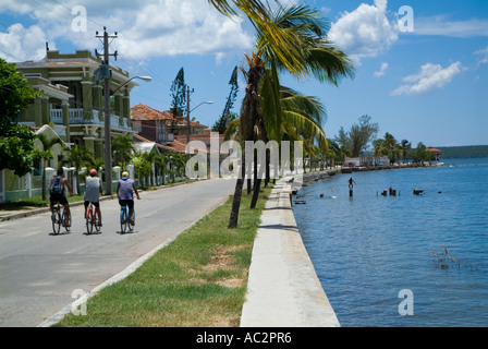 Les hommes randonnée à vélo le long de la rue ensemble par la baie de Cienfuegos, Cuba, Punta Gorda. Banque D'Images