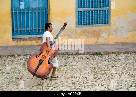 Cuba - musicien man walking down Simon Bolivar et porteur d'une contrebasse à Trinidad, Cuba Banque D'Images