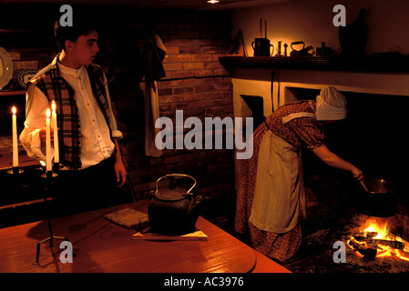 L'homme et la femme habillée comme fonctionnaires du xixe siècle dans la cuisine par le feu dans la vieille maison à Saint Andrews, Nouveau-Brunswick, Canada Banque D'Images