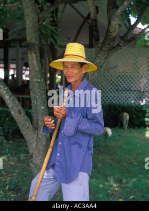 Un vieux fermier thaïlandais à l'ombre tenant une canne de bambou en souriant vers la caméra, Bangkok, Thailande, Asie Banque D'Images