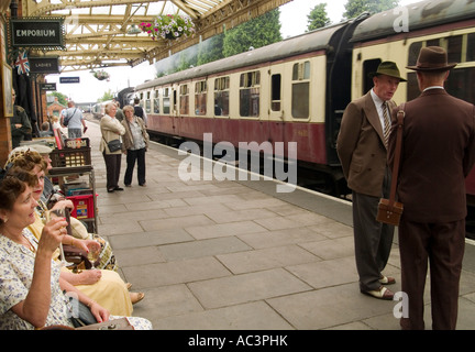 Les gens en costume d'attente sur la plate-forme à la gare de Loughborough, Leicestershire, Great Central Railway Banque D'Images