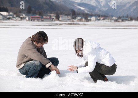 Jeune couple jouant avec de la neige Banque D'Images