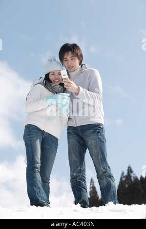 Jeune couple taking photo with mobile phone Banque D'Images