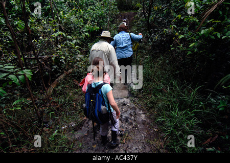 Pérou aventure touristes américains tromp dans la boue sur rainforest trail en vacances à Tahuayo Lodge Banque D'Images