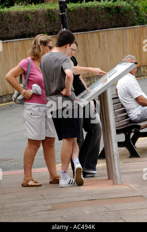 Les touristes les gens vacanciers à la ville à la carte guide d'information à Cowes sur l'île de Wight Banque D'Images