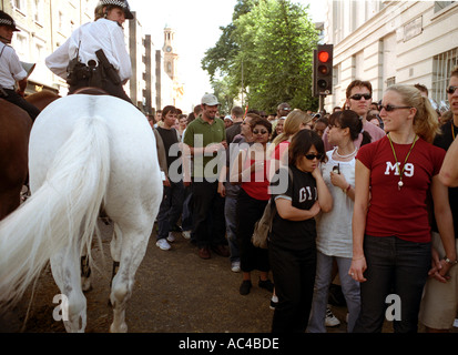 Grande foule soit dirigée et contrôlée par un officier de la police montée dans une rue latérale au carnaval de Notting Hill Gate. Banque D'Images