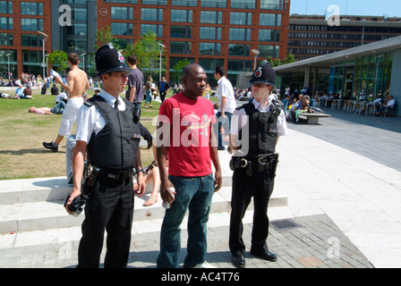 Deux hommes en uniforme de police posent avec homme Afro Antillais des jardins de Piccadilly, Manchester GB UK EU Europe Banque D'Images