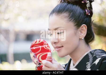 Jeune femme en kimono composent l'application Banque D'Images