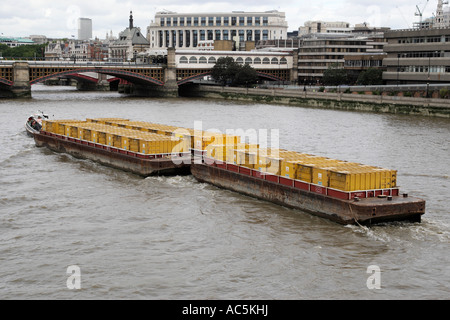 Barge avec des conteneurs de déchets cory en descendant la rivière Thames London England uk Banque D'Images