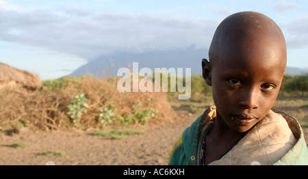 Garçon Masai à boma/village à Engekaret près d'Arusha en Tanzanie. Avec le Mont Meru en arrière-plan Banque D'Images