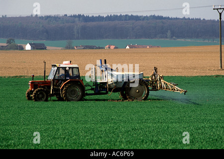 Le tracteur la pulvérisation de pesticides en vert rural crop field à vrchlabi région. République tchèque Banque D'Images