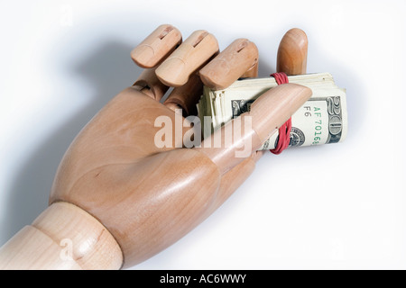 Mannequin articulé en bois hand holding rouleau de dollars américains Banque D'Images