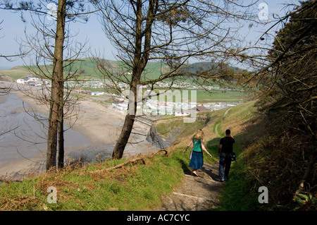 Deux jeunes gens qui marchent le long de la côte de Clarach Ceredigion bay holiday camp à Aberystwyth, Pays de Galles UK Banque D'Images