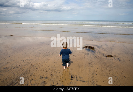 Un jeune garçon explore la mer en vacances à Nice dans le North Yorkshire England UK Banque D'Images