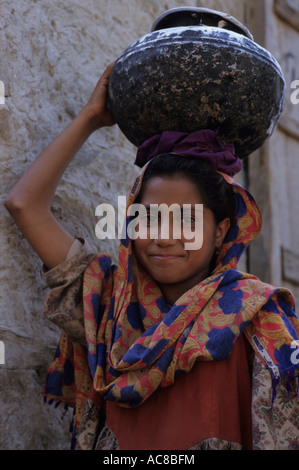 La province de la Frontière du Nord-Ouest du Pakistan jeune fille qui marche à la maison après la collecte de l'eau avec pot sur la tête. Banque D'Images