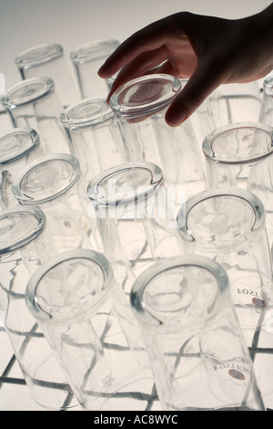Personne dépose de verre vaisselle industrielle Banque D'Images