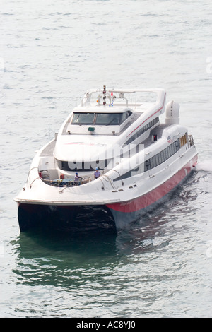 Hong Kong Macao Catamaran turboréacteur entrer Shun Tak Centre ferry terminal avec rétroéclairage et les vapeurs d'échappement de nice Banque D'Images